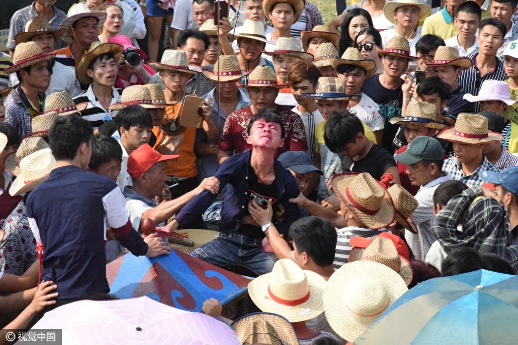 惊悚！海南定安军坡节上演“穿杖”表演，现场人山人海